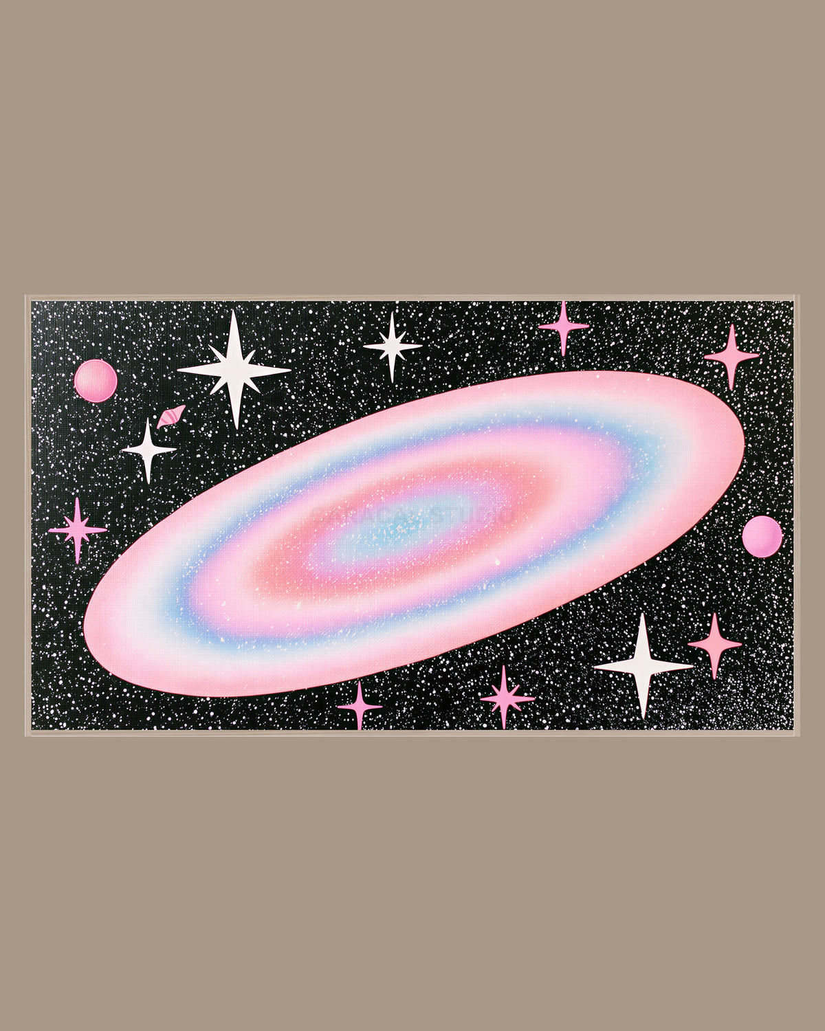 Celestial Frame TV Art of a glowing pastel pink and blue galaxy surrounded by white sparkles, stars and small pink planets on a deep black sky, in a light wood frame on a warm taupe wall