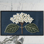 Embroidered hydrangea art on a black TV on a white marble wall