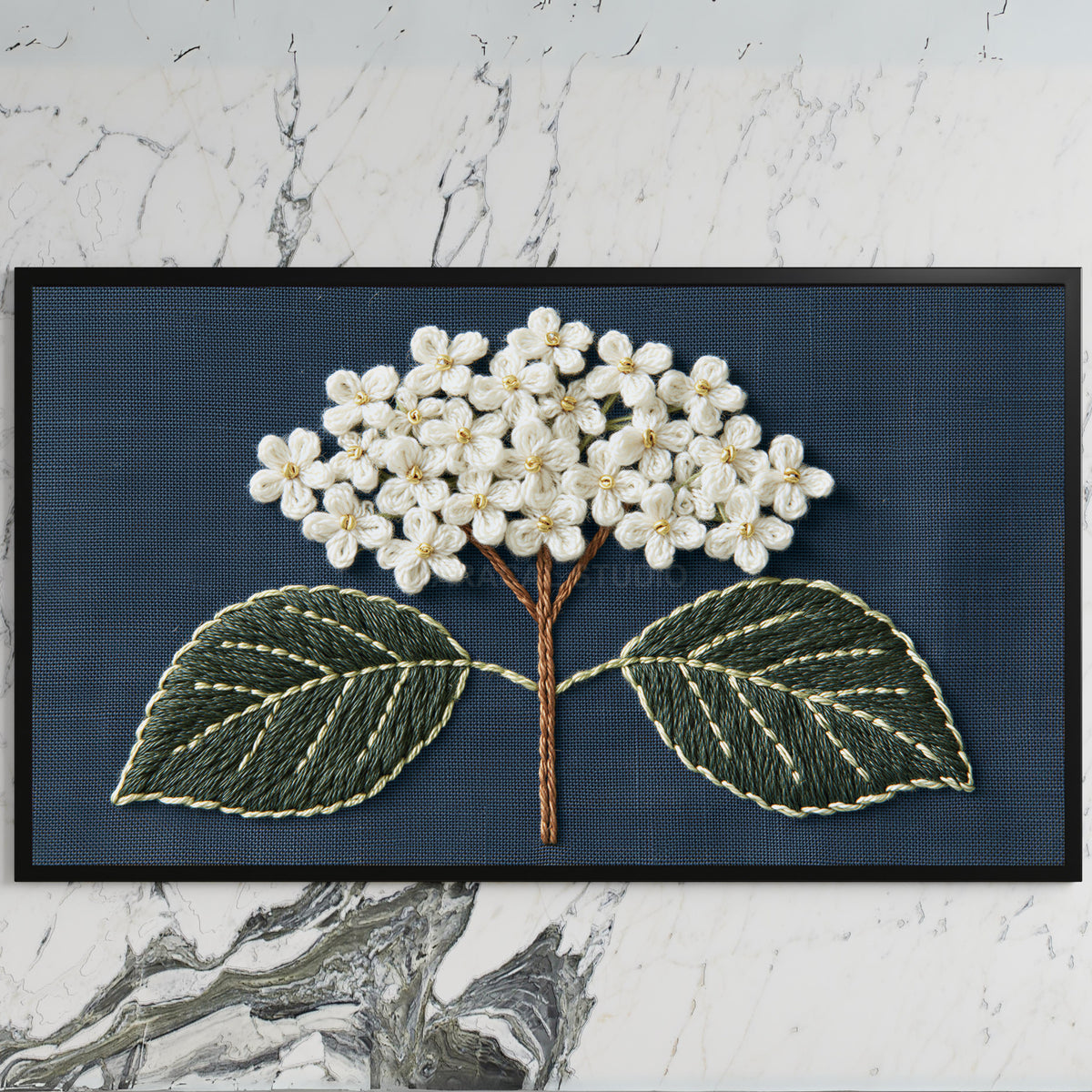 Embroidered hydrangea art on a black TV on a white marble wall