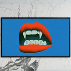 Vampire fangs art on a black TV on a white marble wall