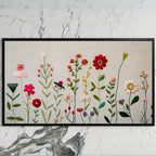 Embroidery style wildflower art on a black TV on a white marble wall