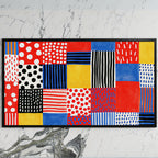 Polka dot patchwork art on a black TV on a white marble wall