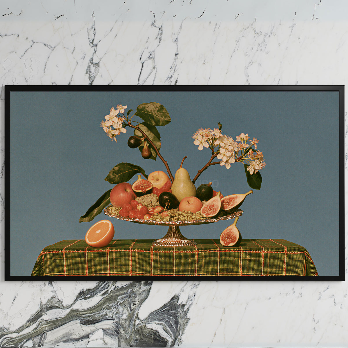 Fruit still life art on a black TV on a white marble wall