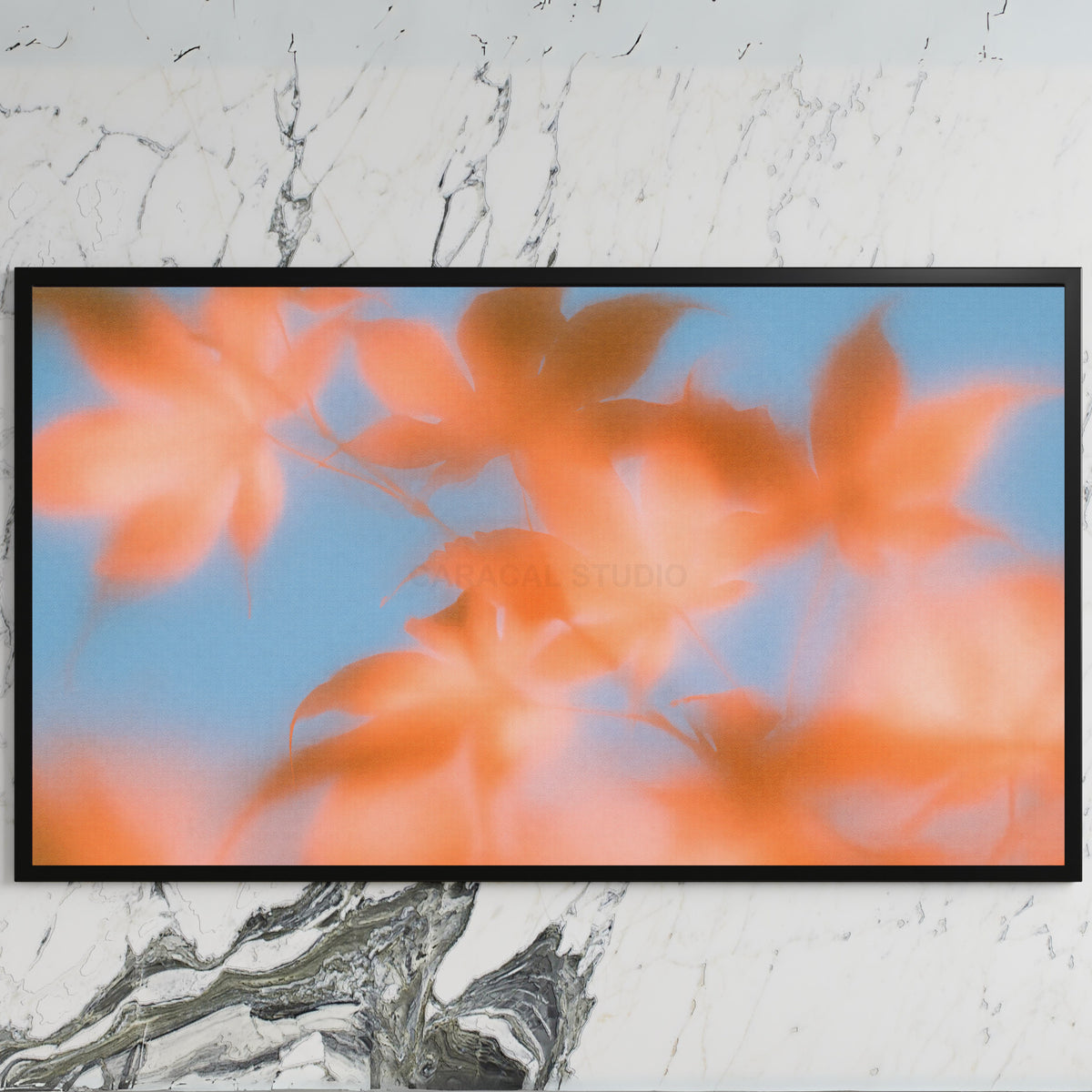 Autumn leaves art on a black TV on a white marble wall