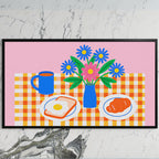 Breakfast table with flowers art on a black TV on a white marble wall