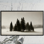 Snowy pine trees art on a black TV on a white marble wall