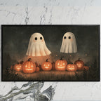 Two ghosts and jack-o'-lanterns art on a black TV on a white marble wall