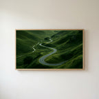 Winding road landscape Frame TV art in an oak frame on a warm white wall