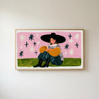 Woman in a big hat Frame TV art in an oak frame on a warm white wall