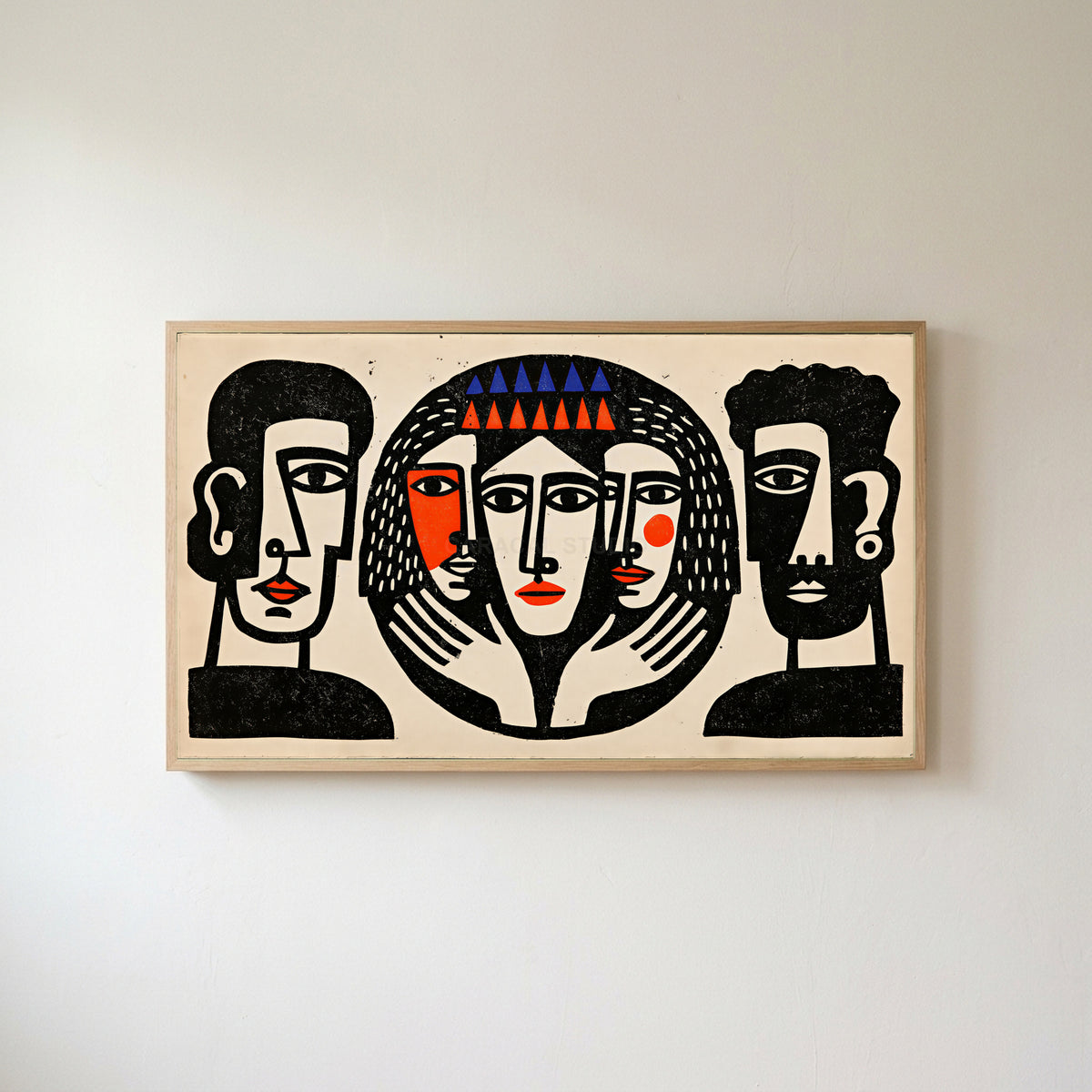 Linocut faces Frame TV art in an oak frame on a warm white wall