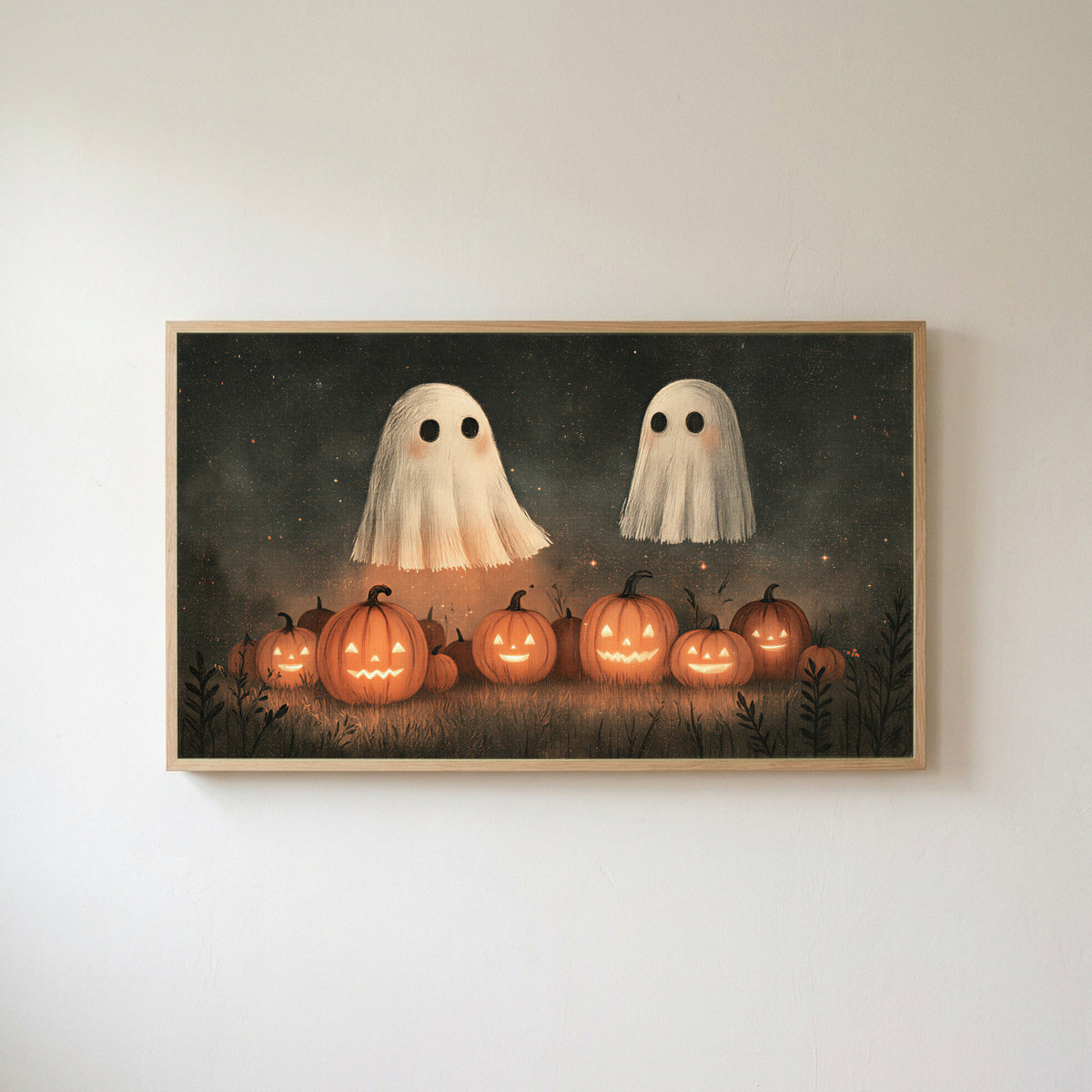 Two ghosts and jack-o'-lanterns Frame TV art in an oak frame on a warm white wall