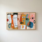 Colorful abstract faces Frame TV art in an oak frame on a warm white wall