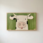 Funny cow Frame TV art in an oak frame on a warm white wall