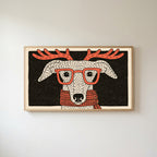 Whippet with reindeer antlers Frame TV art in an oak frame on a warm white wall