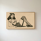Vintage pin-up drawing Frame TV art in an oak frame on a warm white wall
