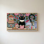 Black cat at a tea party Frame TV art in an oak frame on a warm white wall