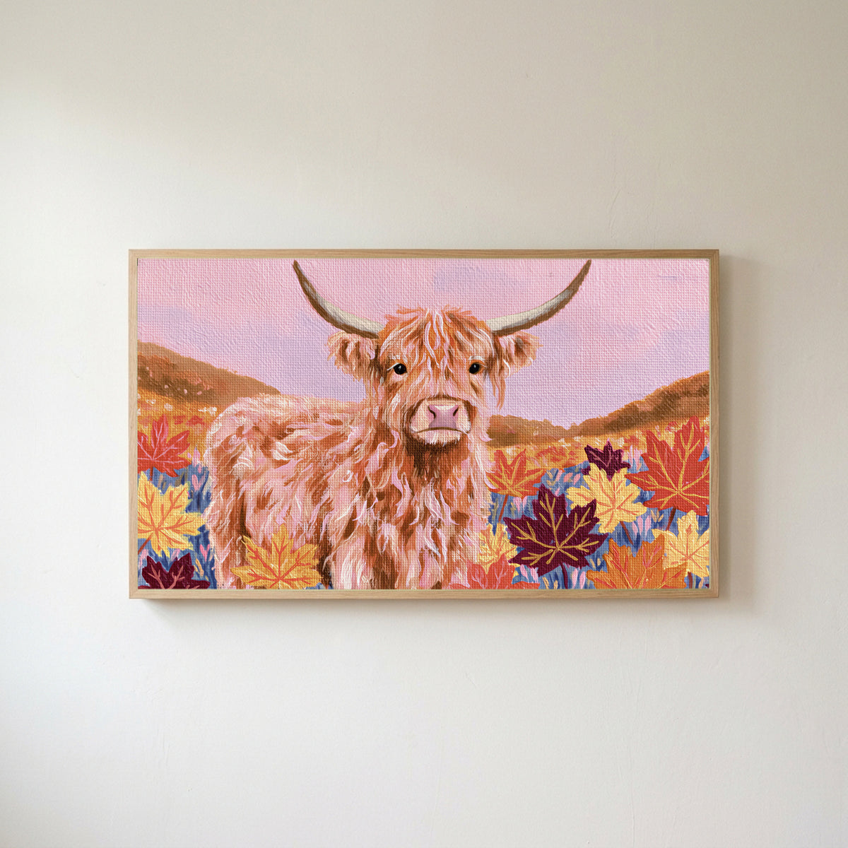 Highland cow in fall leaves Frame TV art in an oak frame on a warm white wall