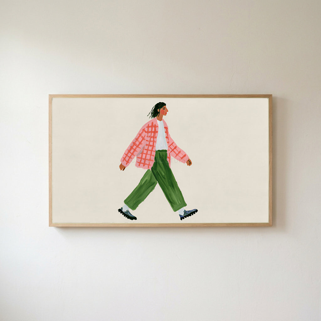 Woman walking Frame TV art in an oak frame on a warm white wall