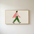 Woman walking Frame TV art in an oak frame on a warm white wall