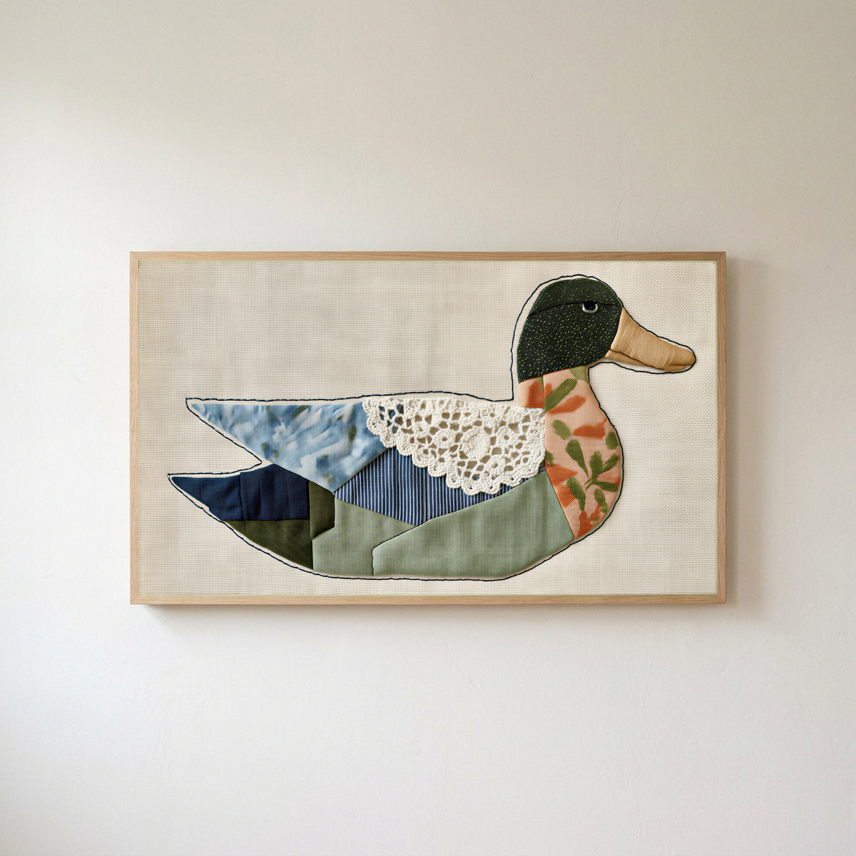 Patchwork duck Frame TV art in an oak frame on a warm white wall