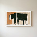 Minimalist black cow Frame TV art in an oak frame on a warm white wall