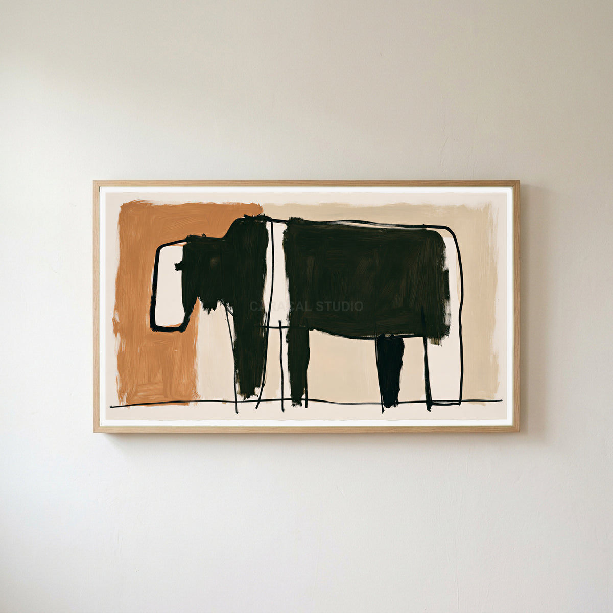 Minimalist black cow Frame TV art in an oak frame on a warm white wall