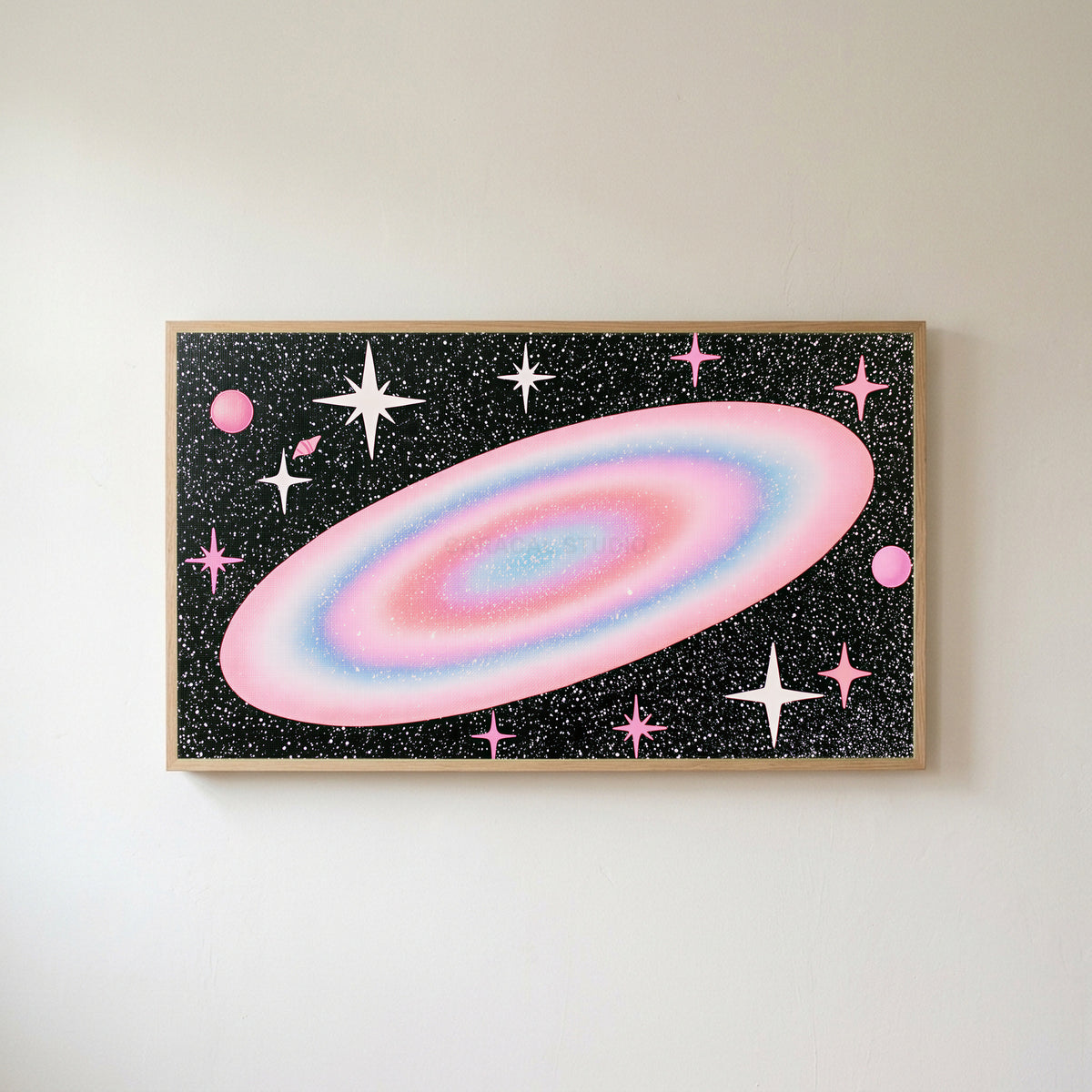 Pastel galaxy Frame TV art in an oak frame on a warm white wall