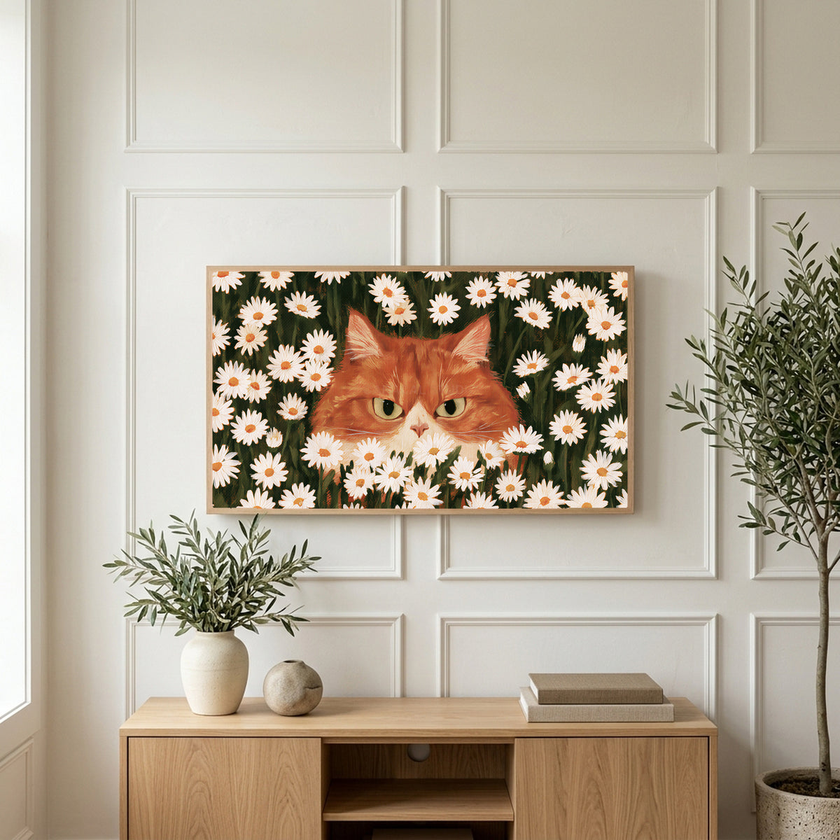 Ginger cat in daisies art on a TV above a light oak sideboard with olive branches in a bright living room