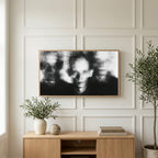 Blurred faces art on a TV above a light oak sideboard with olive branches in a bright living room