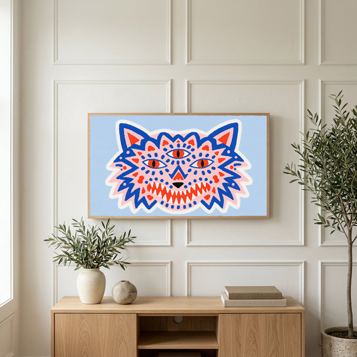 Three-eyed wolf art on a TV above a light oak sideboard with olive branches in a bright living room