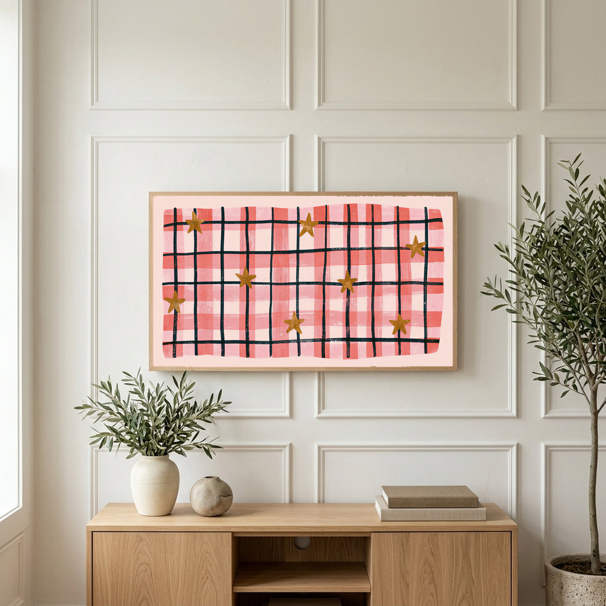 Gingham plaid with stars art on a TV above a light oak sideboard with olive branches in a bright living room