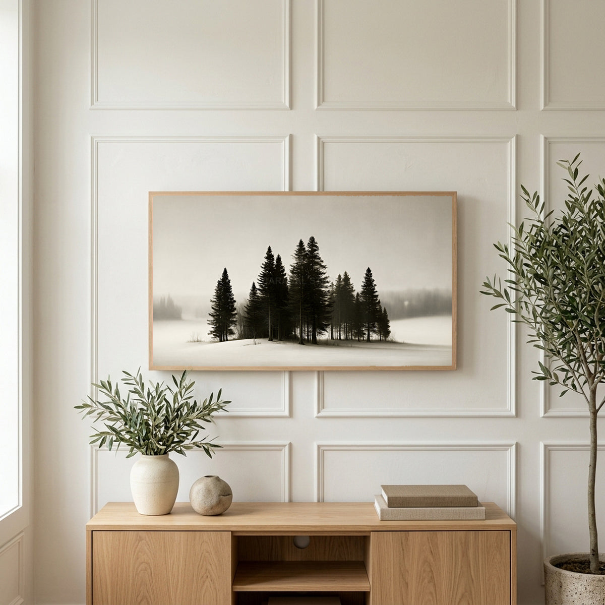 Snowy pine trees art on a TV above a light oak sideboard with olive branches in a bright living room