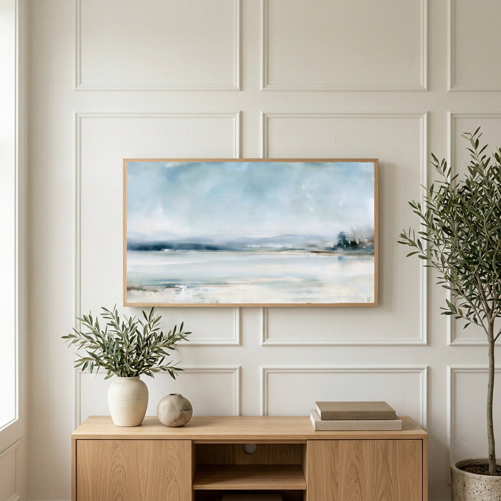 Snowy landscape art on a TV above a light oak sideboard with olive branches in a bright living room
