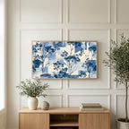 Blue botanical art on a TV above a light oak sideboard with olive branches in a bright living room
