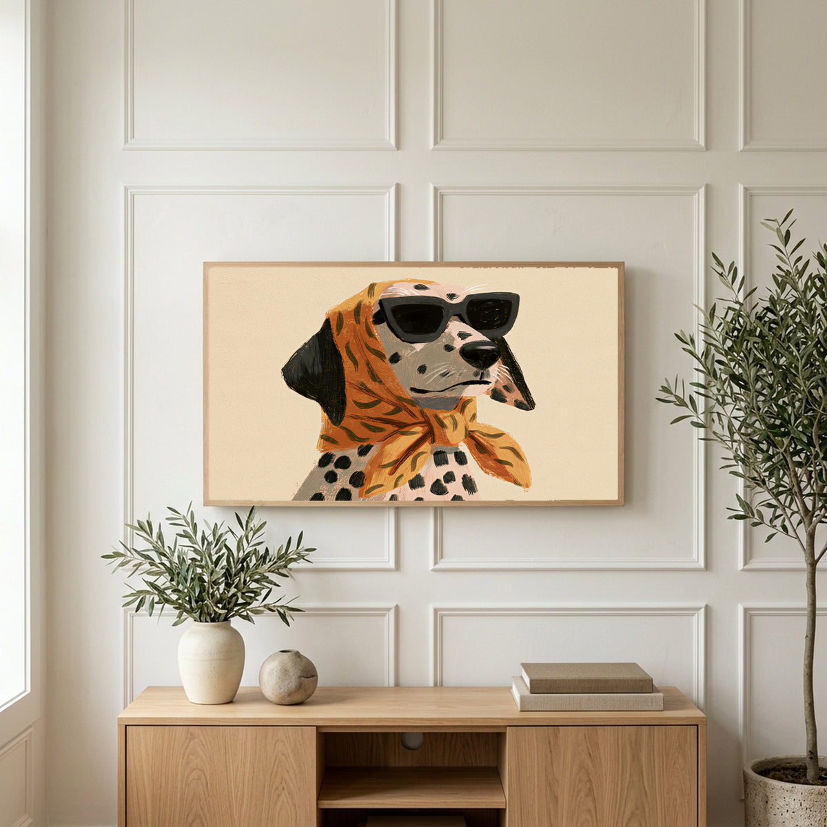 Dalmatian in sunglasses art on a TV above a light oak sideboard with olive branches in a bright living room