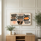 Stacked teacups art on a TV above a light oak sideboard with olive branches in a bright living room