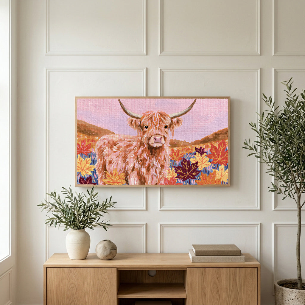 Highland cow in fall leaves art on a TV above a light oak sideboard with olive branches in a bright living room