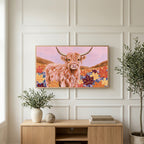 Highland cow in fall leaves art on a TV above a light oak sideboard with olive branches in a bright living room