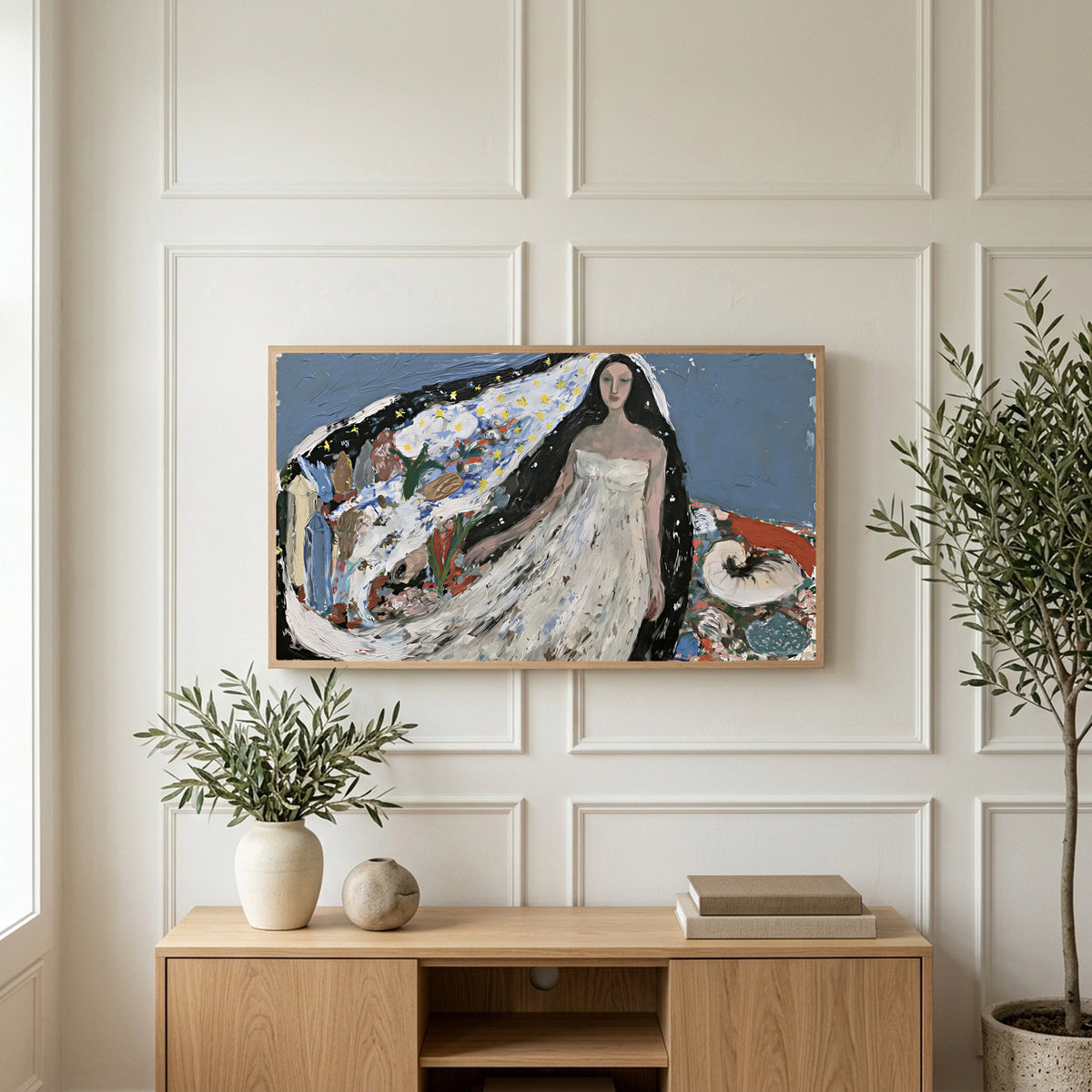 Starry veil woman art on a TV above a light oak sideboard with olive branches in a bright living room
