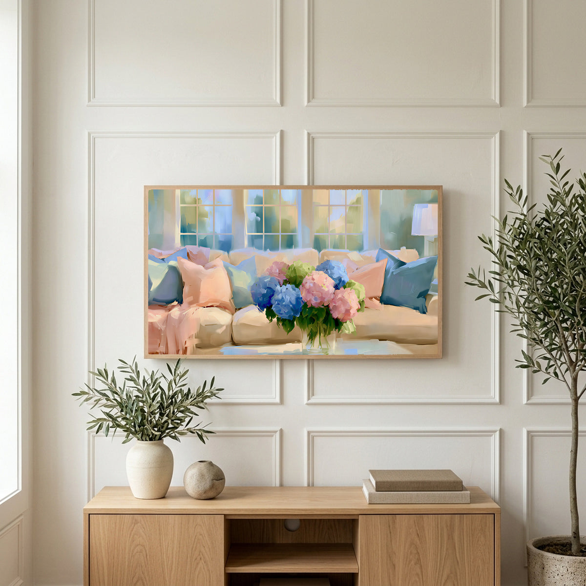 Pastel hydrangea bouquet art on a TV above a light oak sideboard with olive branches in a bright living room
