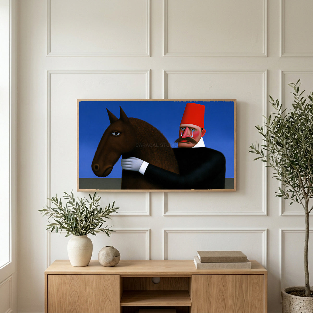 Man in red fez with horse art on a TV above a light oak sideboard with olive branches in a bright living room