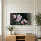 Fluted glass blossom art on a TV above a light oak sideboard with olive branches in a bright living room