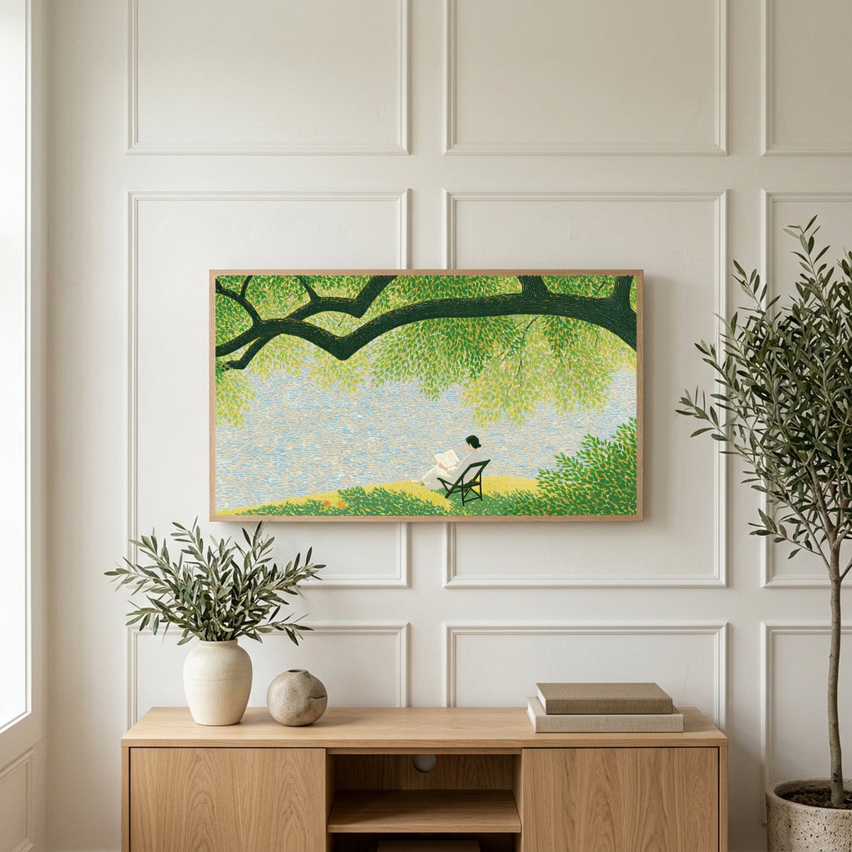 Lake and tree landscape art on a TV above a light oak sideboard with olive branches in a bright living room
