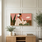 Woman with white flower art on a TV above a light oak sideboard with olive branches in a bright living room