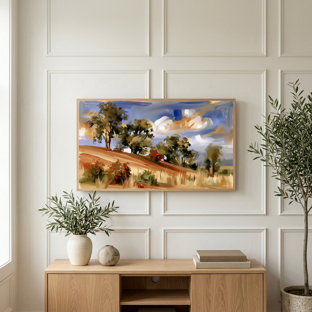 Hillside trees art on a TV above a light oak sideboard with olive branches in a bright living room