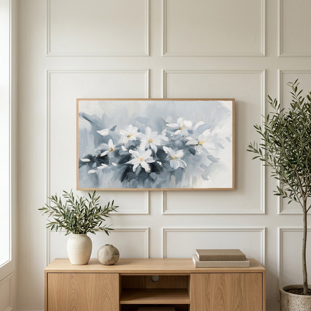 White flower art on a TV above a light oak sideboard with olive branches in a bright living room