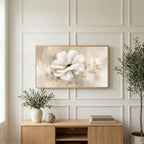 White flower art on a TV above a light oak sideboard with olive branches in a bright living room