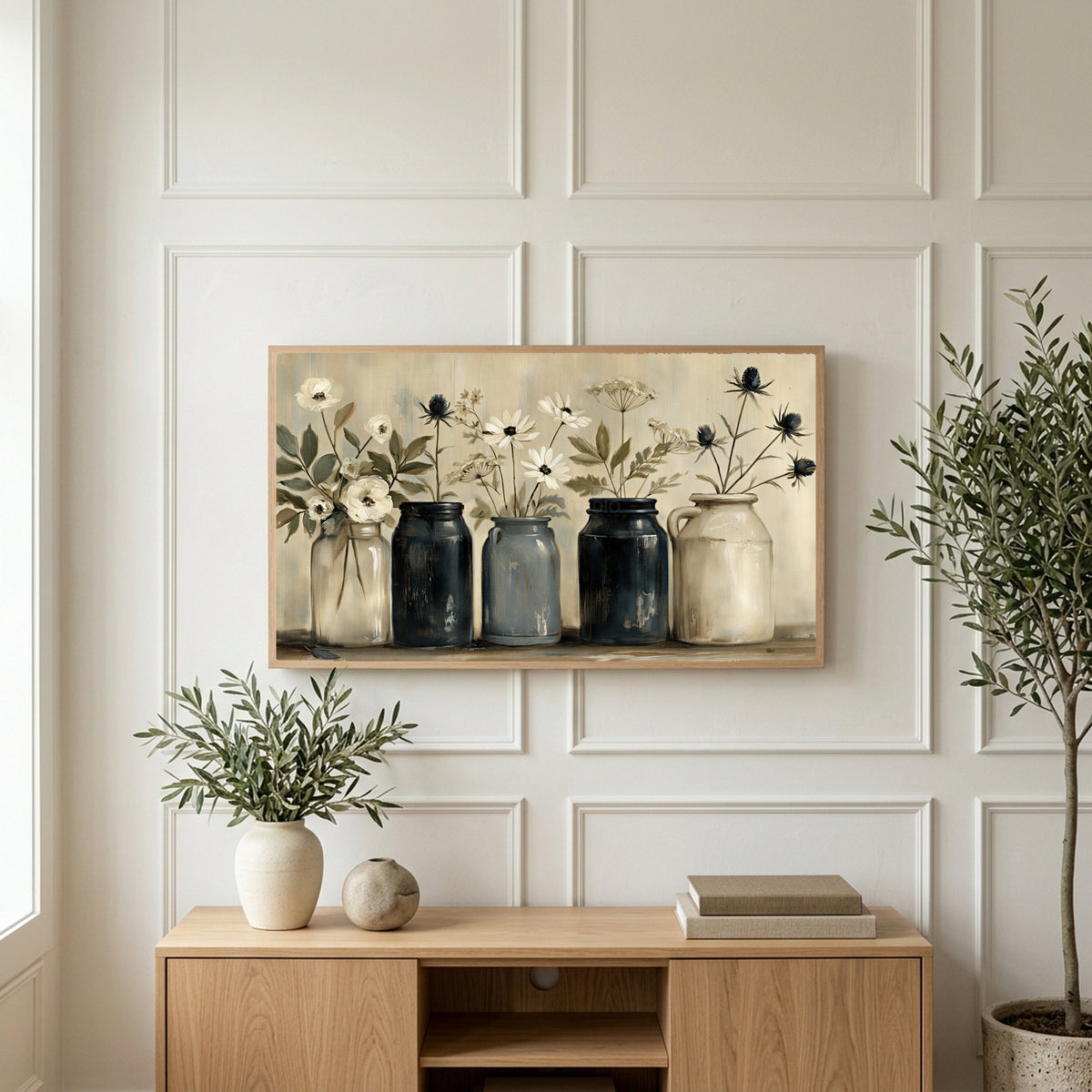 Farmhouse flower jars art on a TV above a light oak sideboard with olive branches in a bright living room