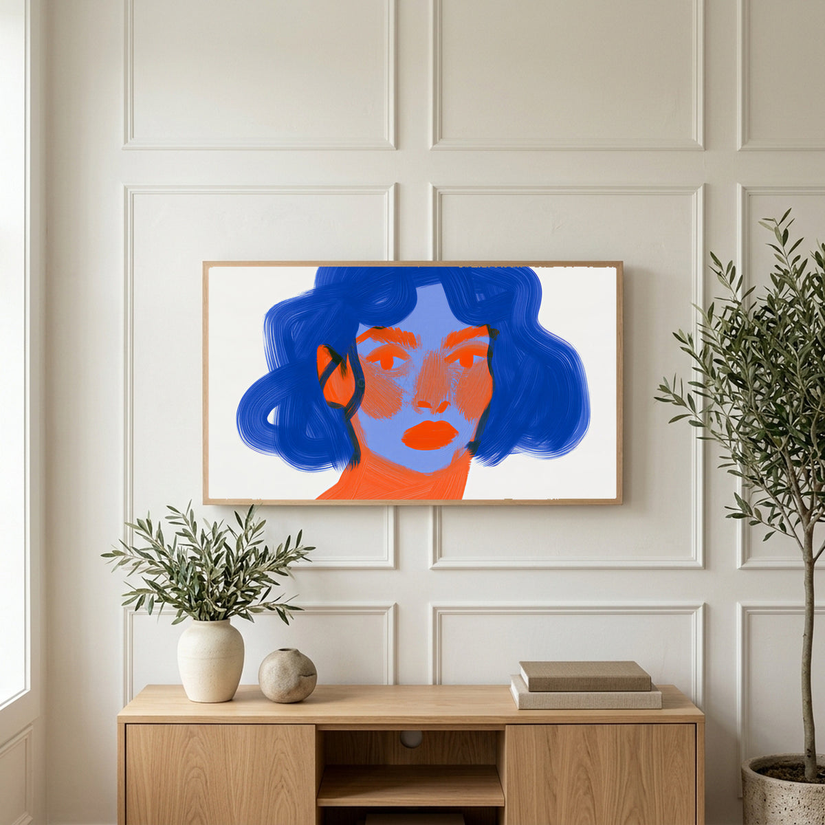 Blue hair portrait art on a TV above a light oak sideboard with olive branches in a bright living room
