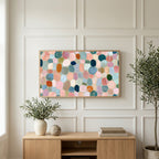Pastel pebble mosaic art on a TV above a light oak sideboard with olive branches in a bright living room
